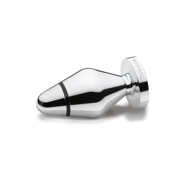 Mystim Little John – E‑Stim Butt Plug aus handpoliertem Aluminium liegend